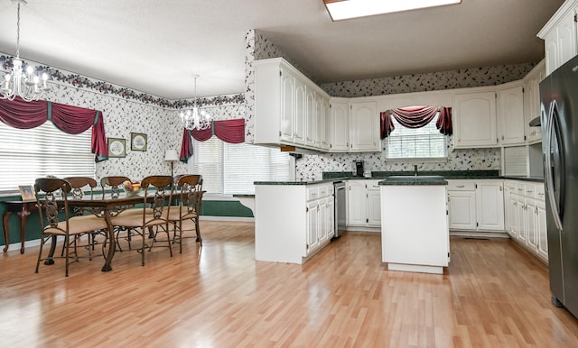 kitchen with stainless steel refrigerator, light wood-type flooring, a center island, and white cabinetry