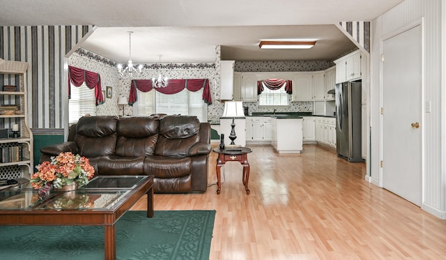 living room with light hardwood / wood-style floors, a chandelier, and sink