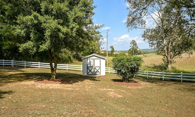 view of yard featuring a rural view and a storage unit