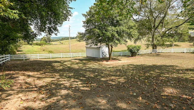 view of yard featuring a storage shed and a rural view