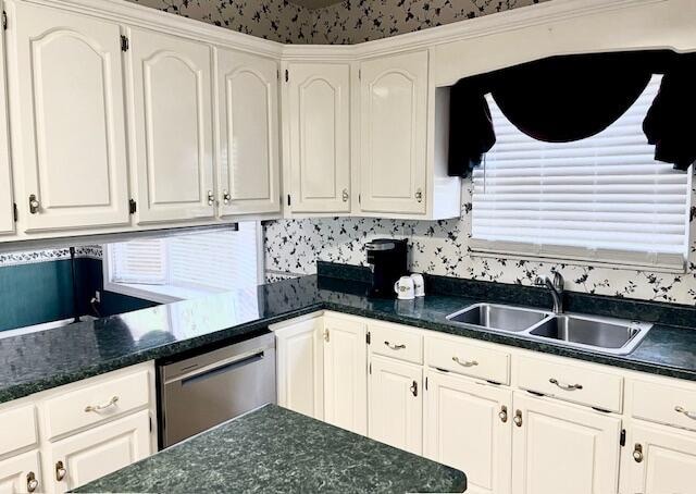 kitchen featuring white cabinets, dishwasher, plenty of natural light, and decorative backsplash