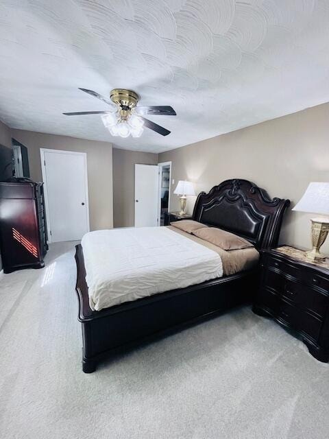 bedroom with ceiling fan and light colored carpet