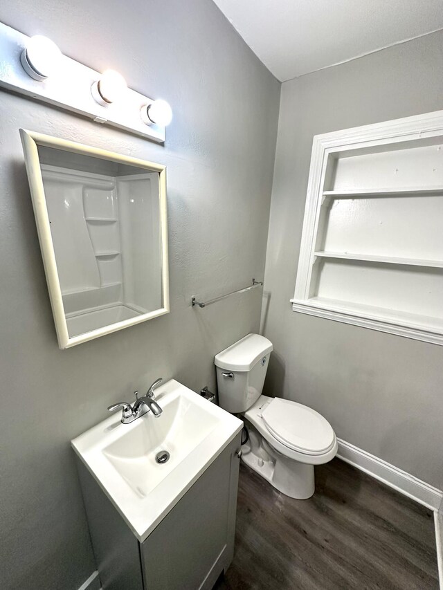 bathroom with hardwood / wood-style flooring, vanity, and toilet