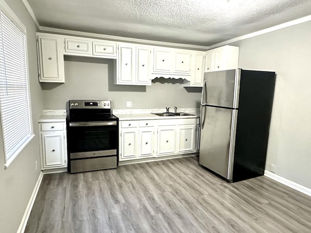 2 Bell Ave, Rossville, GA 30741 - kitchen with light countertops, a sink, light wood-type flooring, stainless steel appliances, and white cabinets