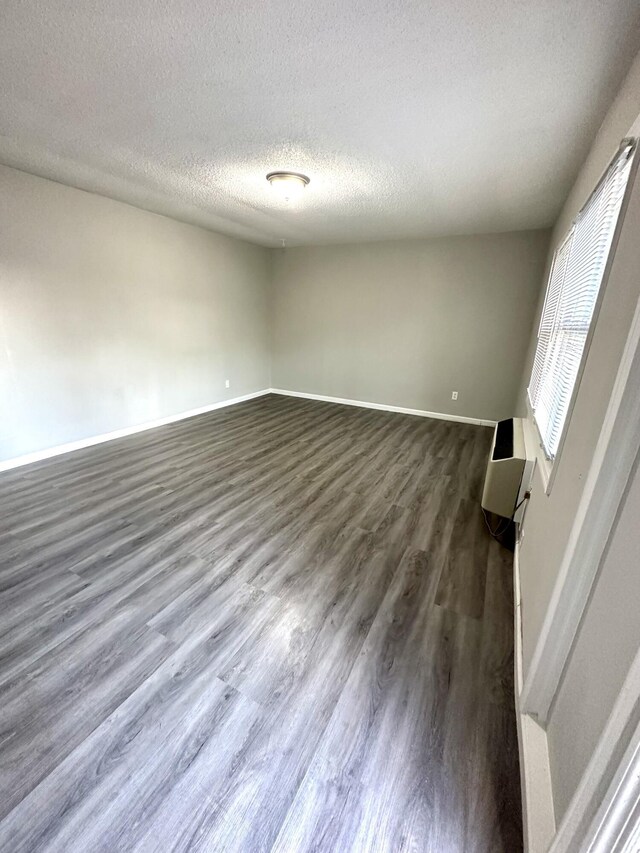 interior space with a textured ceiling and dark hardwood / wood-style flooring