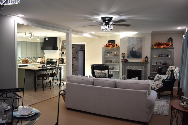 living room with ceiling fan, ornamental molding, and light tile patterned floors