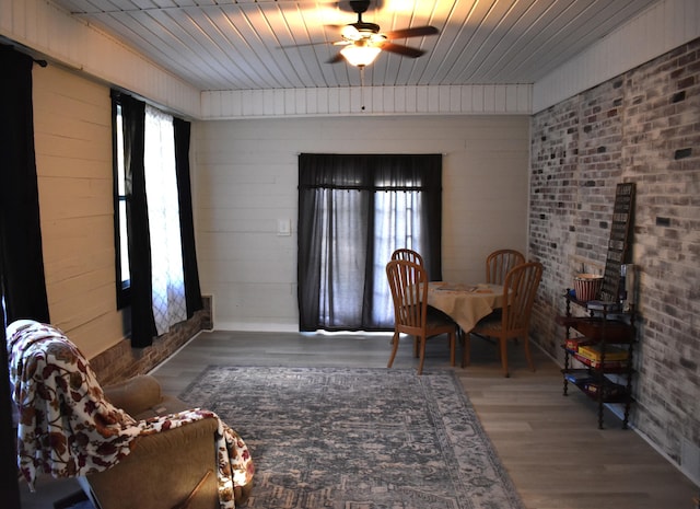 dining space featuring wood-type flooring, wood ceiling, and ceiling fan