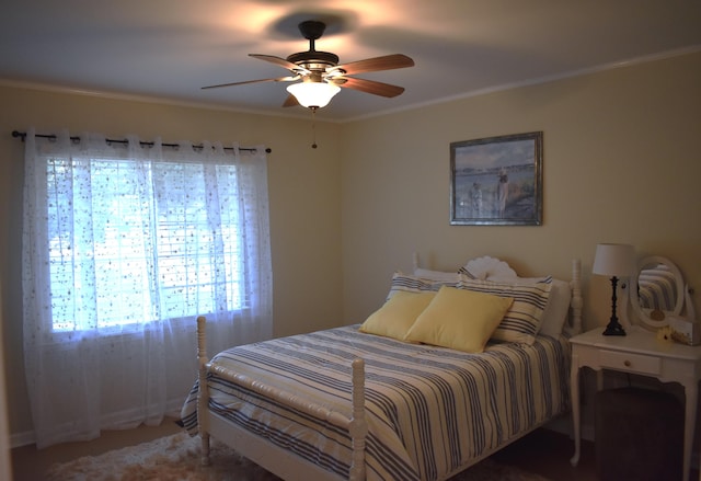 carpeted bedroom featuring ceiling fan and crown molding