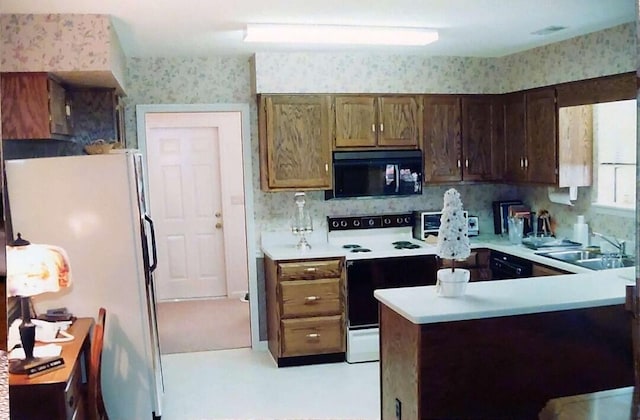 kitchen featuring hanging light fixtures, kitchen peninsula, sink, and white appliances