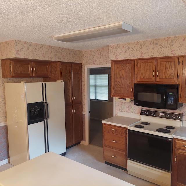 kitchen featuring a textured ceiling and white appliances