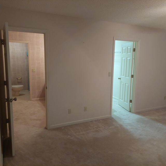 unfurnished room with light carpet and a textured ceiling