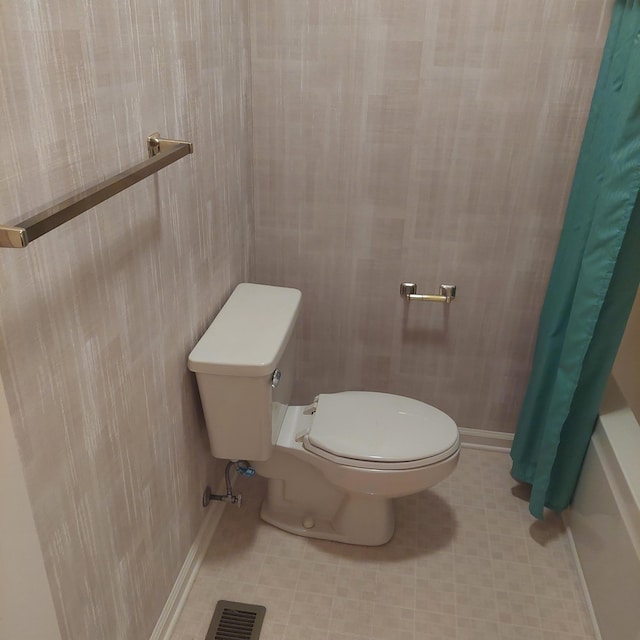 bathroom featuring curtained shower and toilet