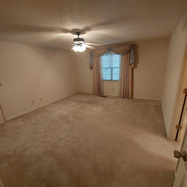 empty room featuring carpet, ceiling fan, and a textured ceiling