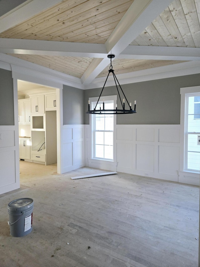 unfurnished dining area featuring a notable chandelier, beamed ceiling, and wooden ceiling