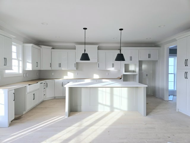 kitchen with white cabinets, pendant lighting, and a kitchen island