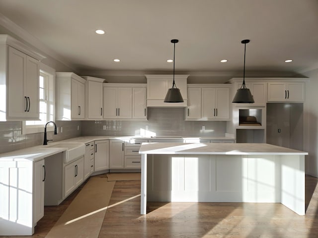 kitchen featuring a kitchen island, white cabinets, and decorative light fixtures