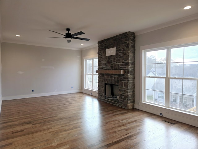 unfurnished living room with crown molding, a fireplace, dark hardwood / wood-style flooring, and ceiling fan