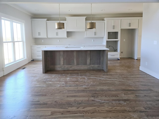 kitchen with white cabinetry, pendant lighting, dark hardwood / wood-style flooring, and a center island with sink