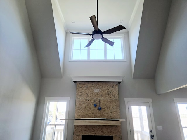 unfurnished living room with a wealth of natural light and ceiling fan