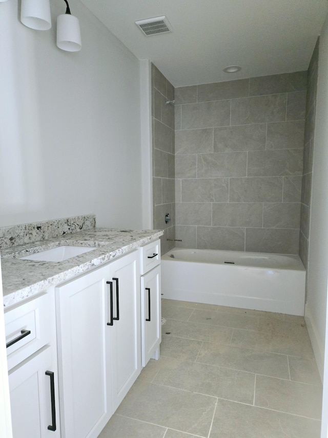 bathroom with vanity, tile patterned flooring, and tiled shower / bath combo