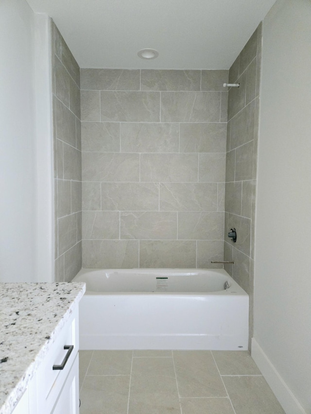 bathroom with tile patterned flooring, vanity, and tiled shower / bath