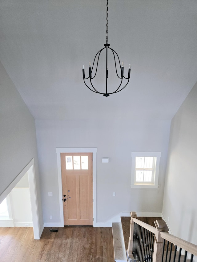 foyer entrance with hardwood / wood-style floors and a chandelier