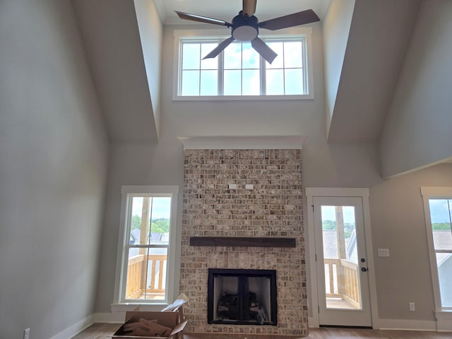 9877 Trestle Cir Unit 46, Ooltewah, TN 37363 - unfurnished living room with a high ceiling, ceiling fan, a brick fireplace, baseboards, and plenty of natural light