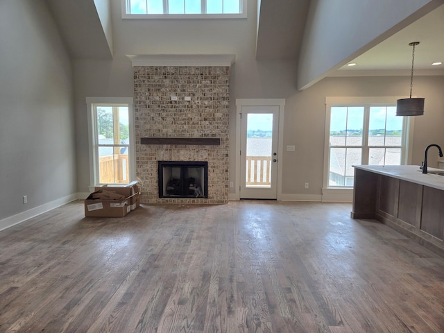 9877 Trestle Cir Unit 46, Ooltewah, TN 37363 - unfurnished living room featuring a towering ceiling, plenty of natural light, wood finished floors, and a fireplace