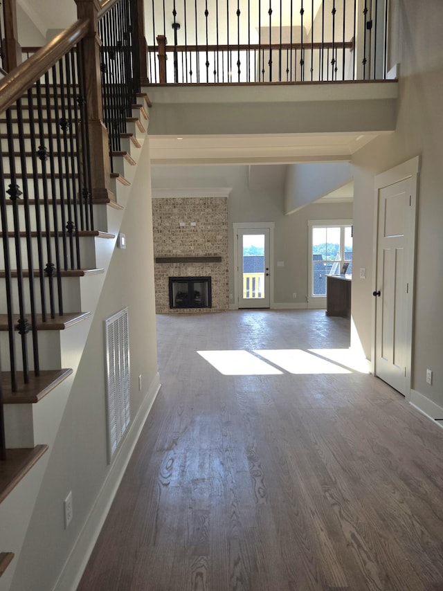 9877 Trestle Cir Unit 46, Ooltewah, TN 37363 - unfurnished living room featuring stairs, wood finished floors, a towering ceiling, and a fireplace