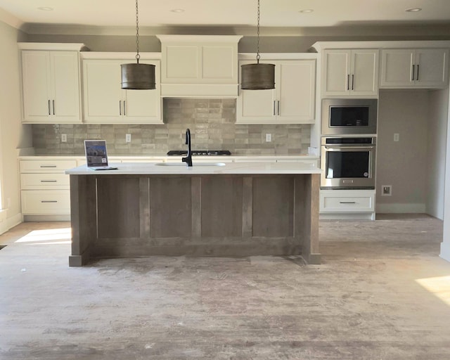 9877 Trestle Cir Unit 46, Ooltewah, TN 37363 - kitchen with appliances with stainless steel finishes, a kitchen island with sink, backsplash, and hanging light fixtures