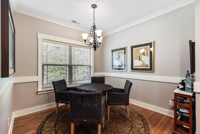 dining area with crown molding, a notable chandelier, and dark hardwood / wood-style floors