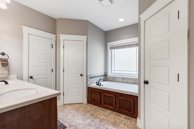 bathroom with vanity, tile patterned flooring, and a bathing tub