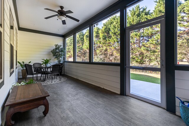 sunroom / solarium featuring a healthy amount of sunlight and ceiling fan