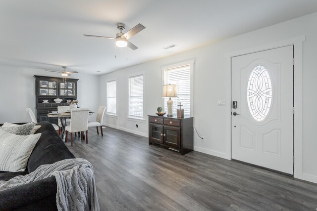 foyer entrance with ceiling fan and dark wood-type flooring