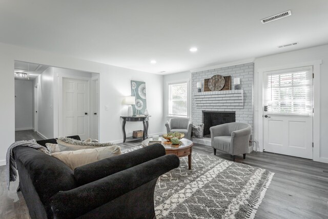 living room with a fireplace, hardwood / wood-style floors, and a healthy amount of sunlight