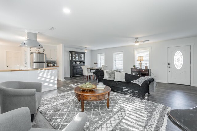 living room featuring dark wood-type flooring and ceiling fan