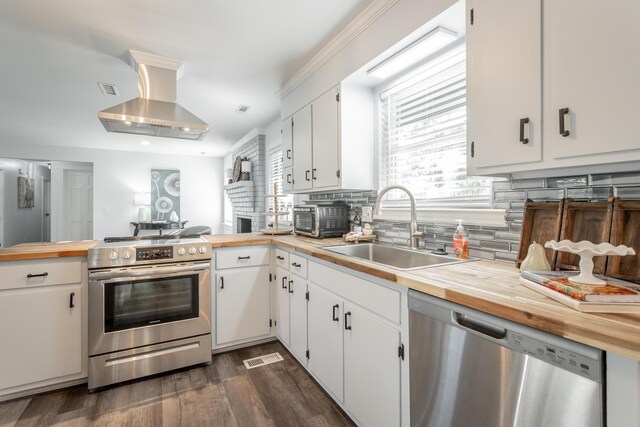 kitchen featuring sink, range hood, white cabinets, stainless steel appliances, and dark hardwood / wood-style flooring