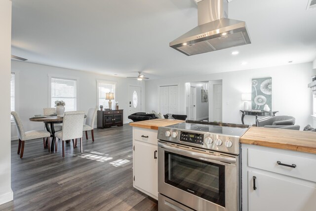 kitchen with white cabinets, island range hood, stainless steel electric stove, dark hardwood / wood-style flooring, and wood counters