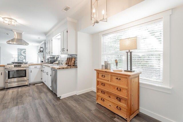 kitchen with stainless steel appliances, wall chimney exhaust hood, dark hardwood / wood-style flooring, and white cabinetry