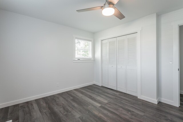 unfurnished bedroom with ceiling fan, a closet, and dark wood-type flooring