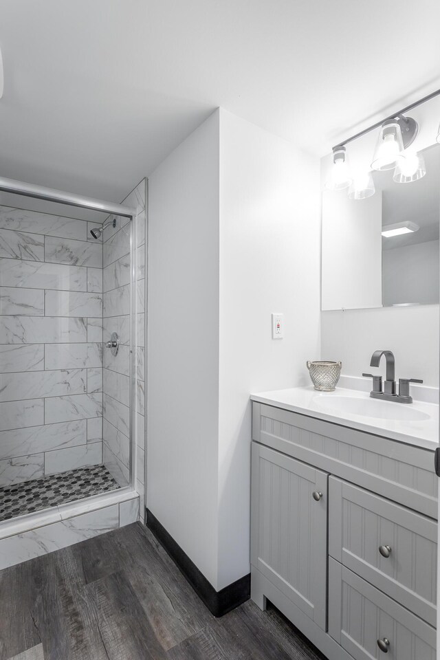 bathroom featuring wood-type flooring, vanity, and a shower with shower door