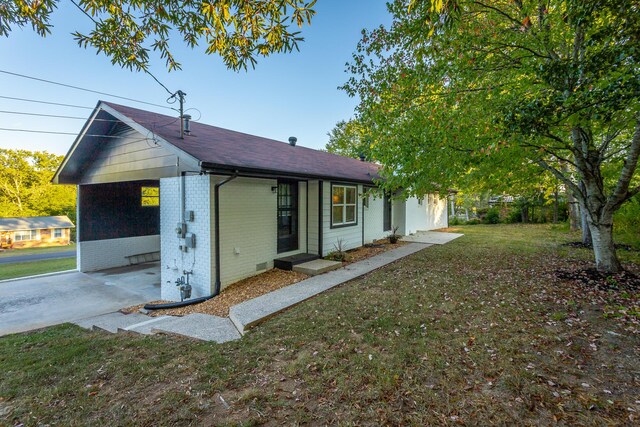 view of front of property featuring a front yard and a carport