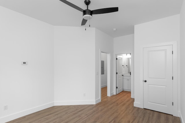 unfurnished bedroom featuring wood-type flooring, connected bathroom, and ceiling fan