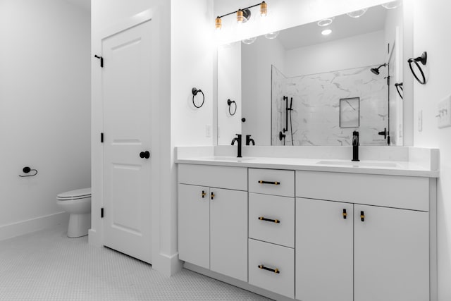 bathroom with tile patterned flooring, toilet, vanity, and tiled shower