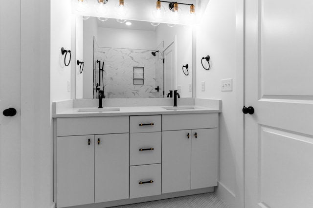 bathroom with tiled shower, vanity, and tile patterned floors