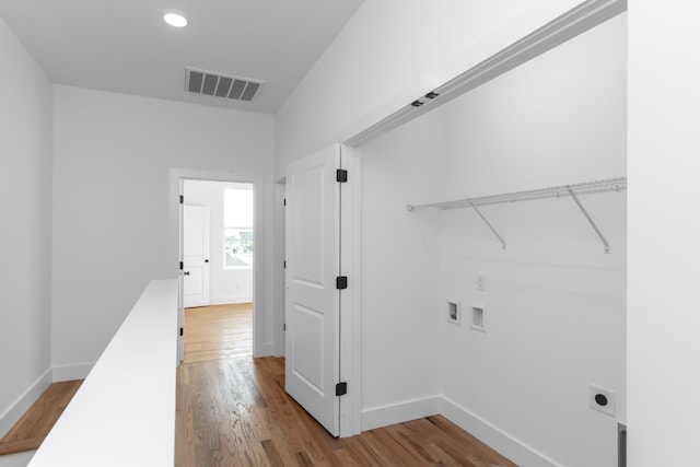 clothes washing area featuring washer hookup, electric dryer hookup, and light hardwood / wood-style flooring