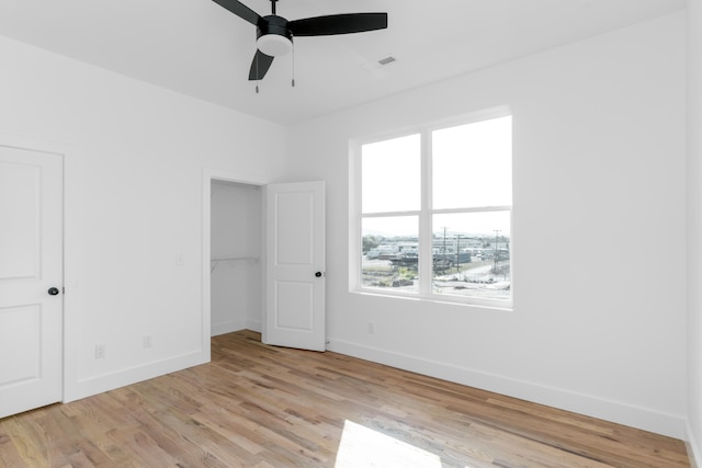 unfurnished bedroom with ceiling fan, light wood-type flooring, and a closet