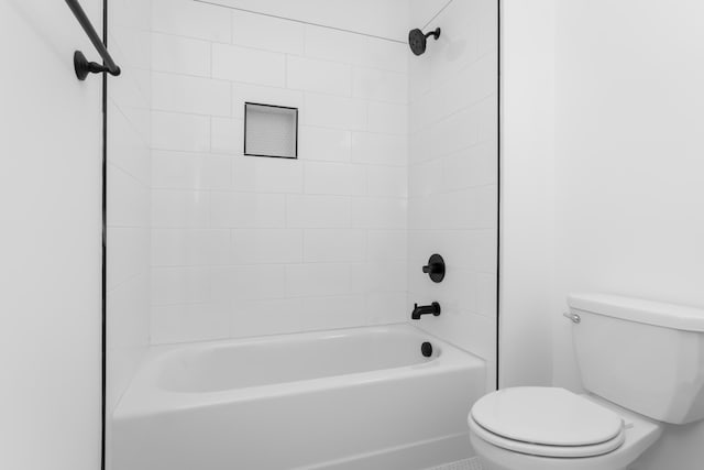 bathroom with tiled shower / bath and toilet