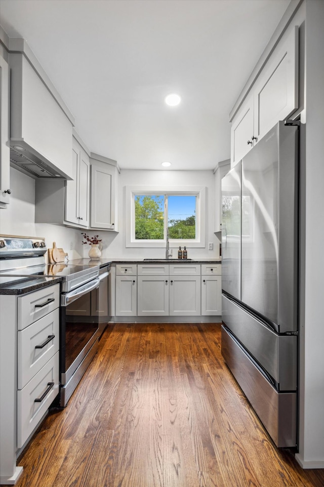 kitchen with appliances with stainless steel finishes, dark wood-type flooring, and sink