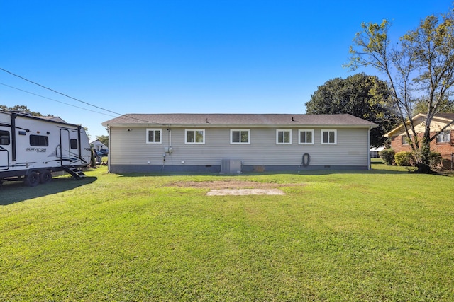 back of property with cooling unit and a lawn